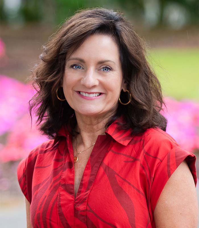 Meet Our Team - Professional and Welcoming Group at a Conference Table Faces the Camera, Team Leader Sitting on the Table with Arms Folded